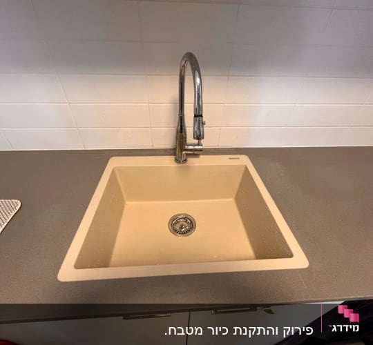 כיור שיש במטבח עם ברז מתכת מבריק